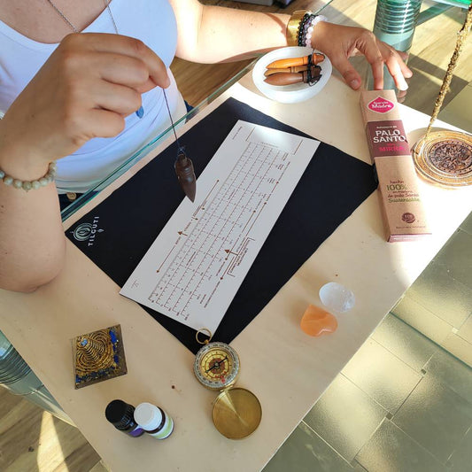 Pêndulo em madeira sobre gráfico radiestésico utilizado no Método TILGUTI® na prática da Radiestesia Consciente®