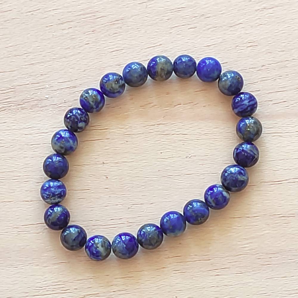 Pulseira de Lápis-Lazúli natural com esferas de 8 mm, tradicionalmente associada à intuição, clareza mental e proteção psíquica.